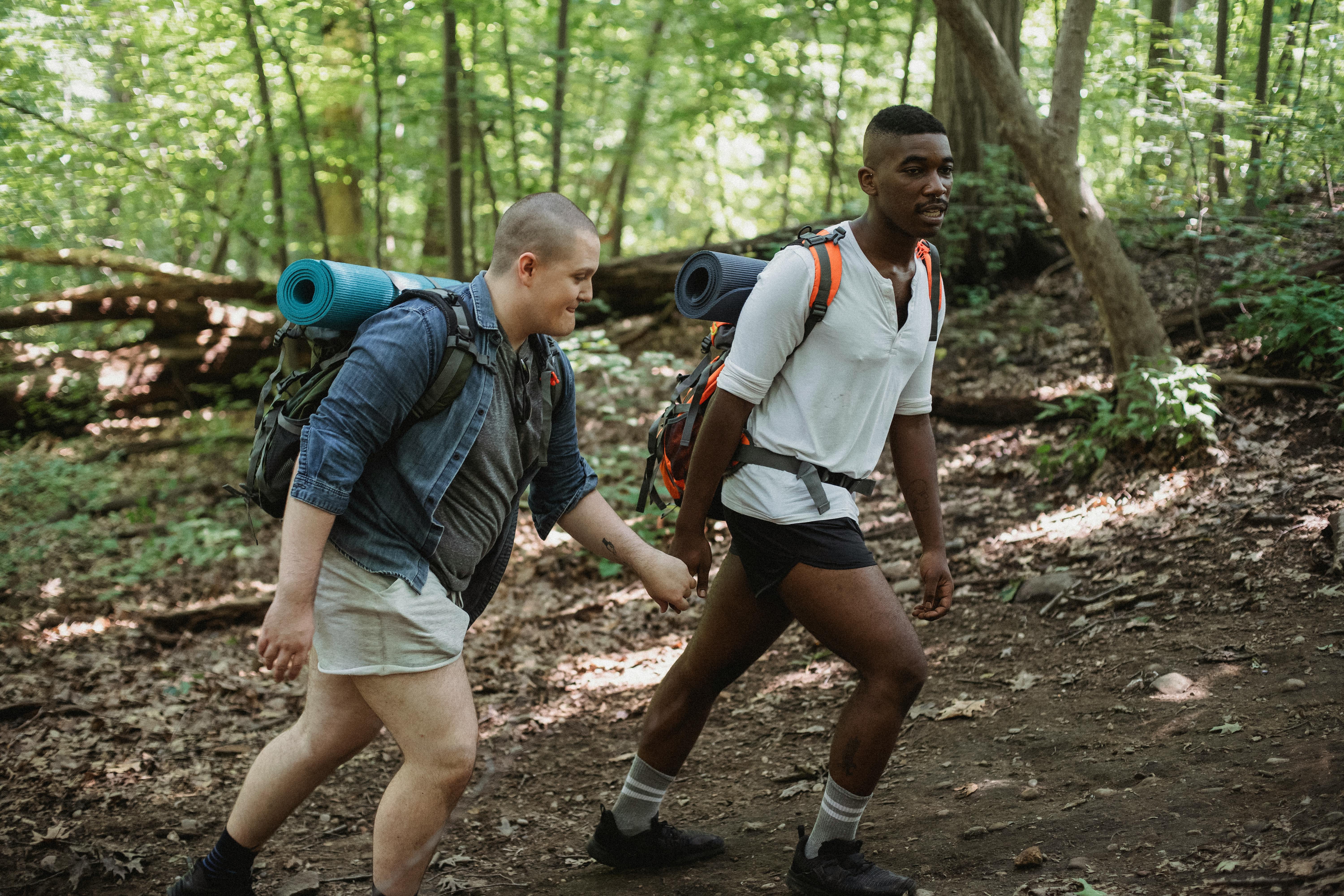 young multiethnic homosexual couple trekking in nature