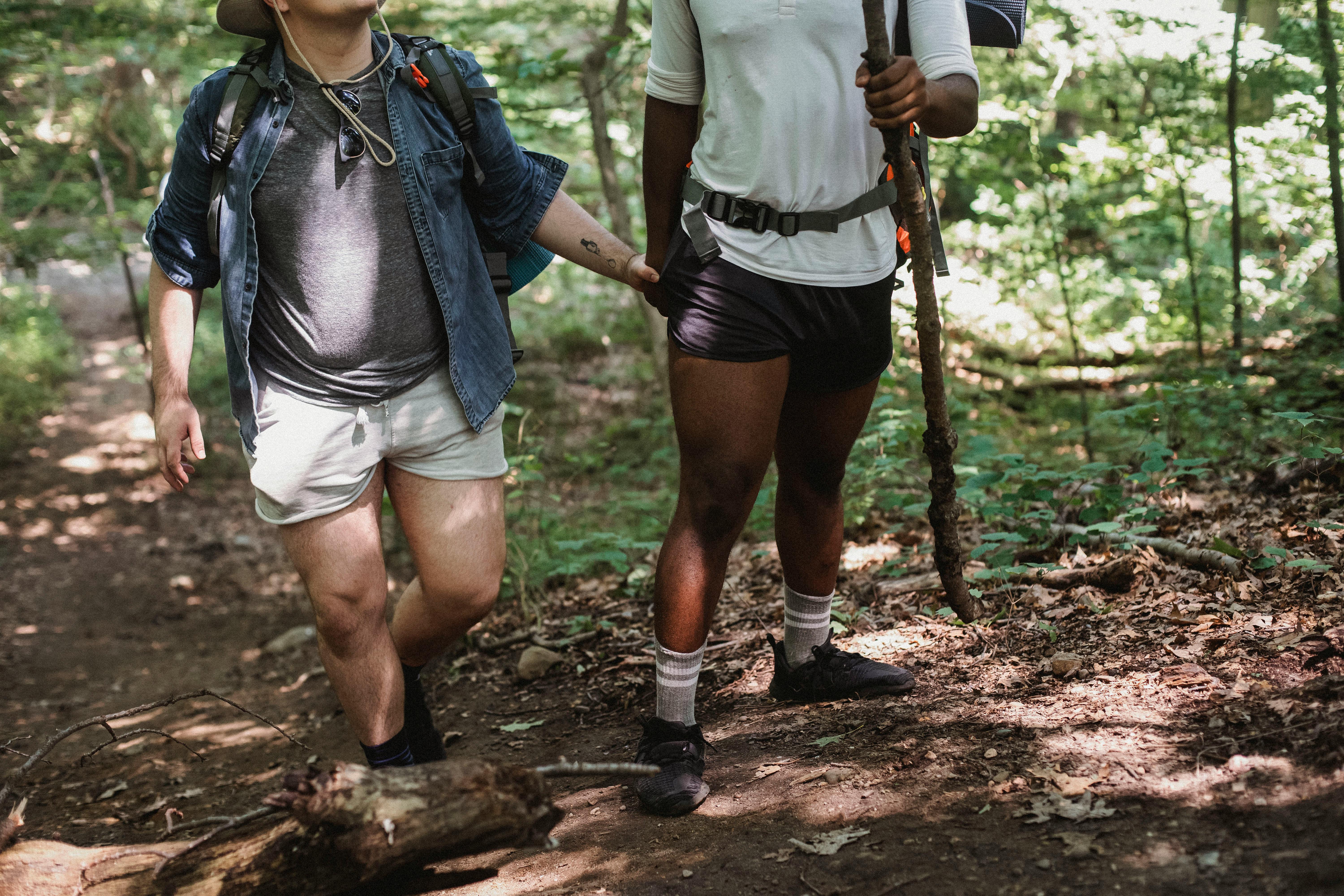 multiethnic travelers climbing in forest