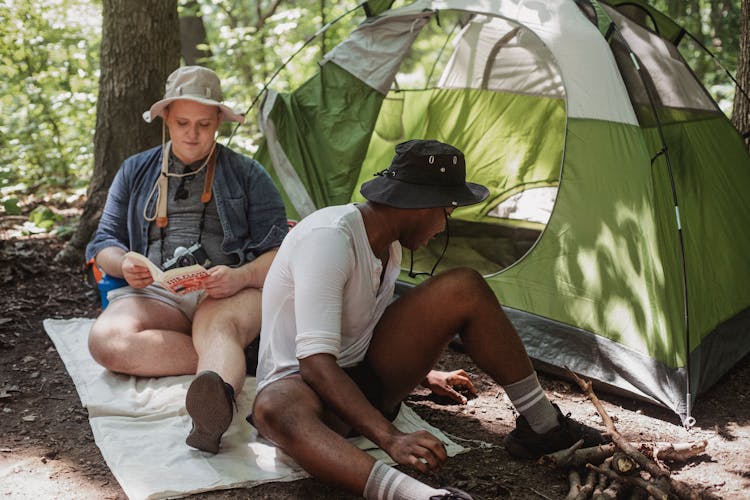 Positive Young Friends Enjoying Camping Together In Summer Forest