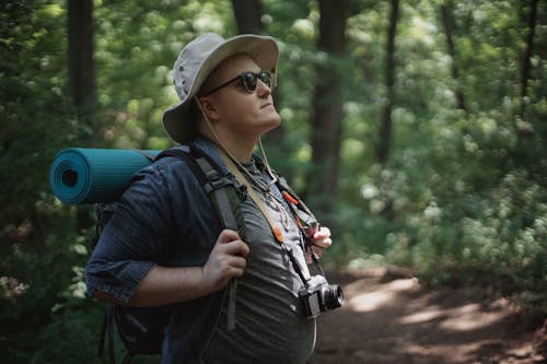 Free Male backpacker in sunglasses exploring summer woods Stock Photo