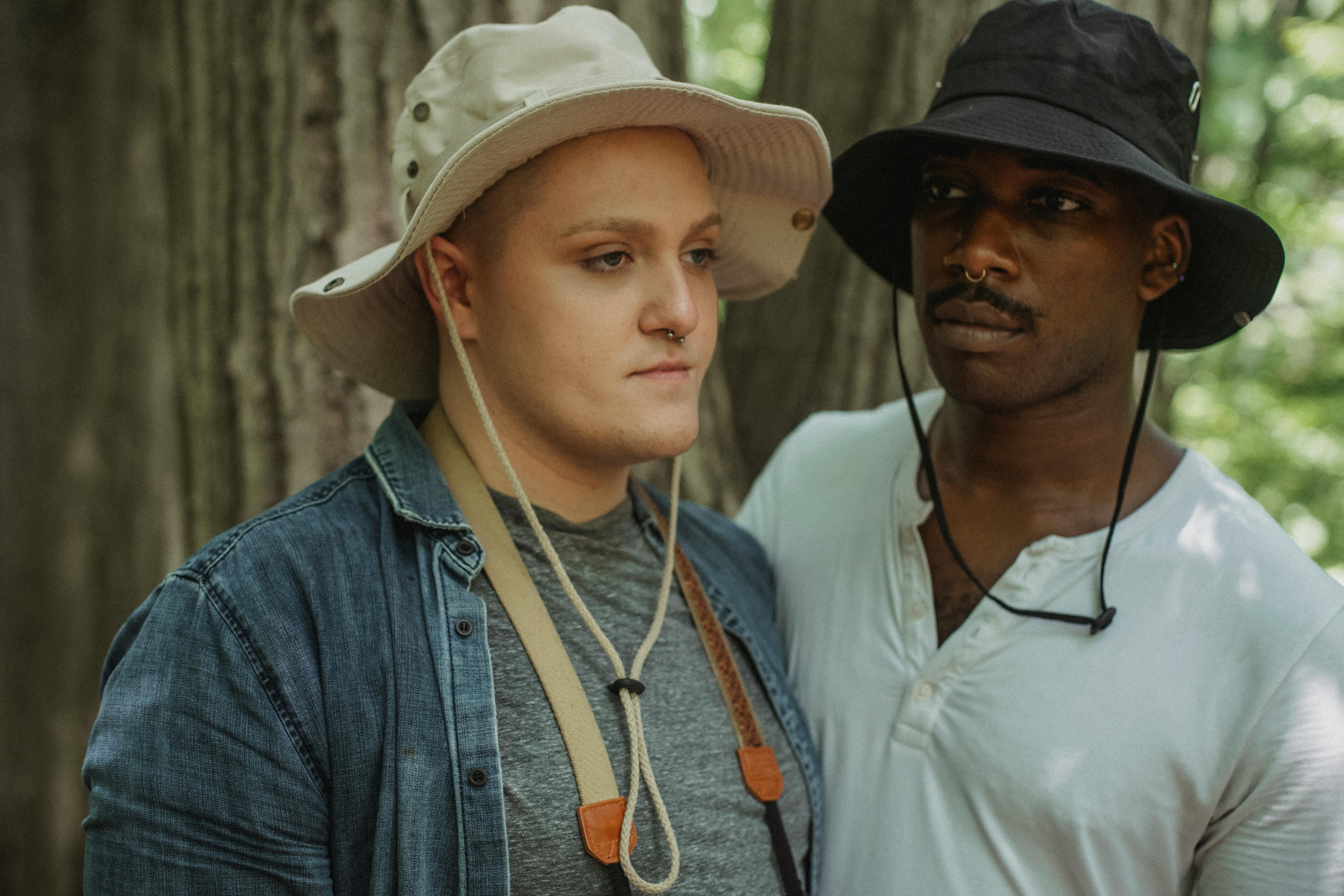 diverse couple of gays near tree in forest