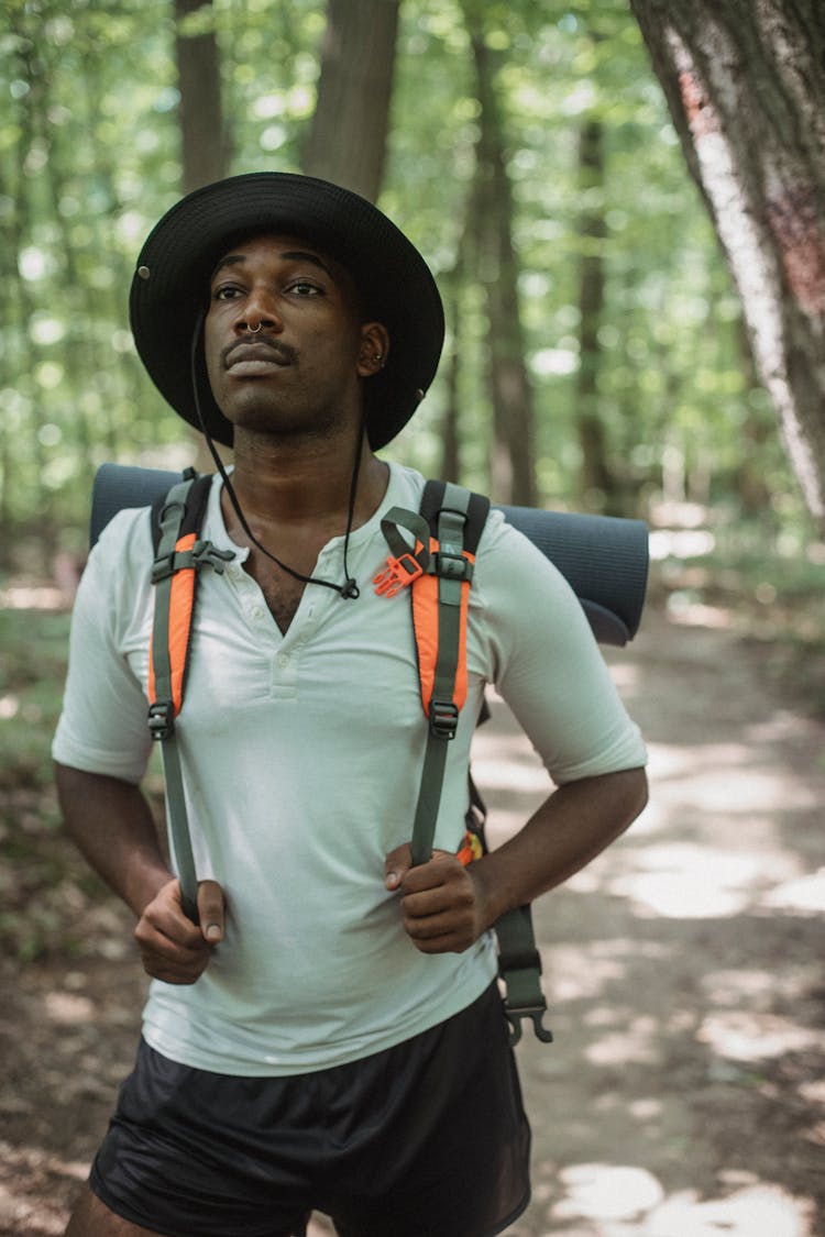 Unemotional Black Hiker On Path In Forest