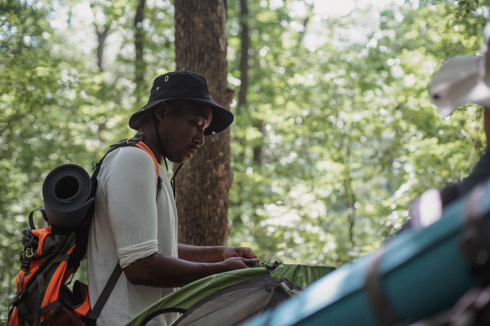 hiker setting up tent wilderness