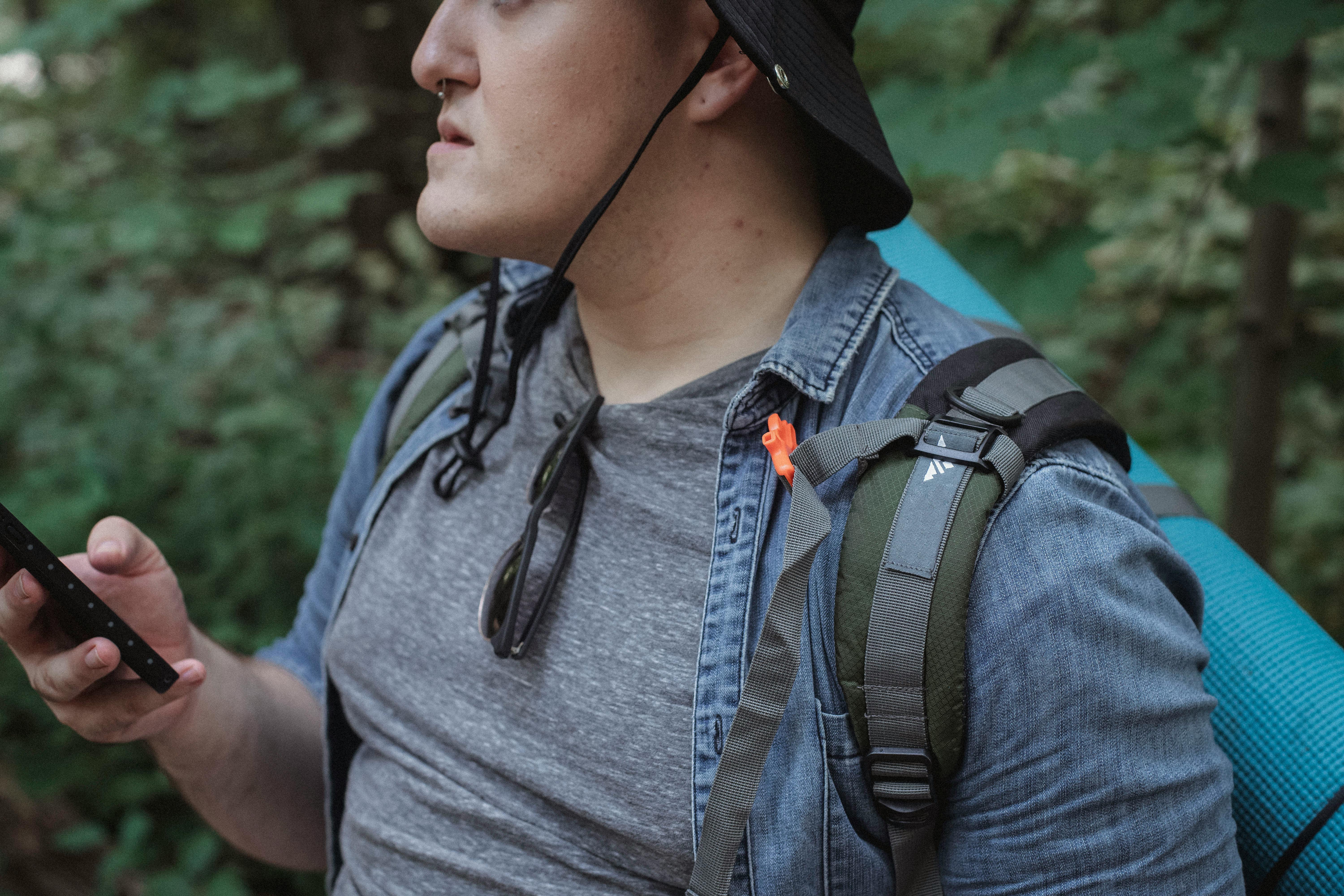 crop male hiker with smartphone in woods