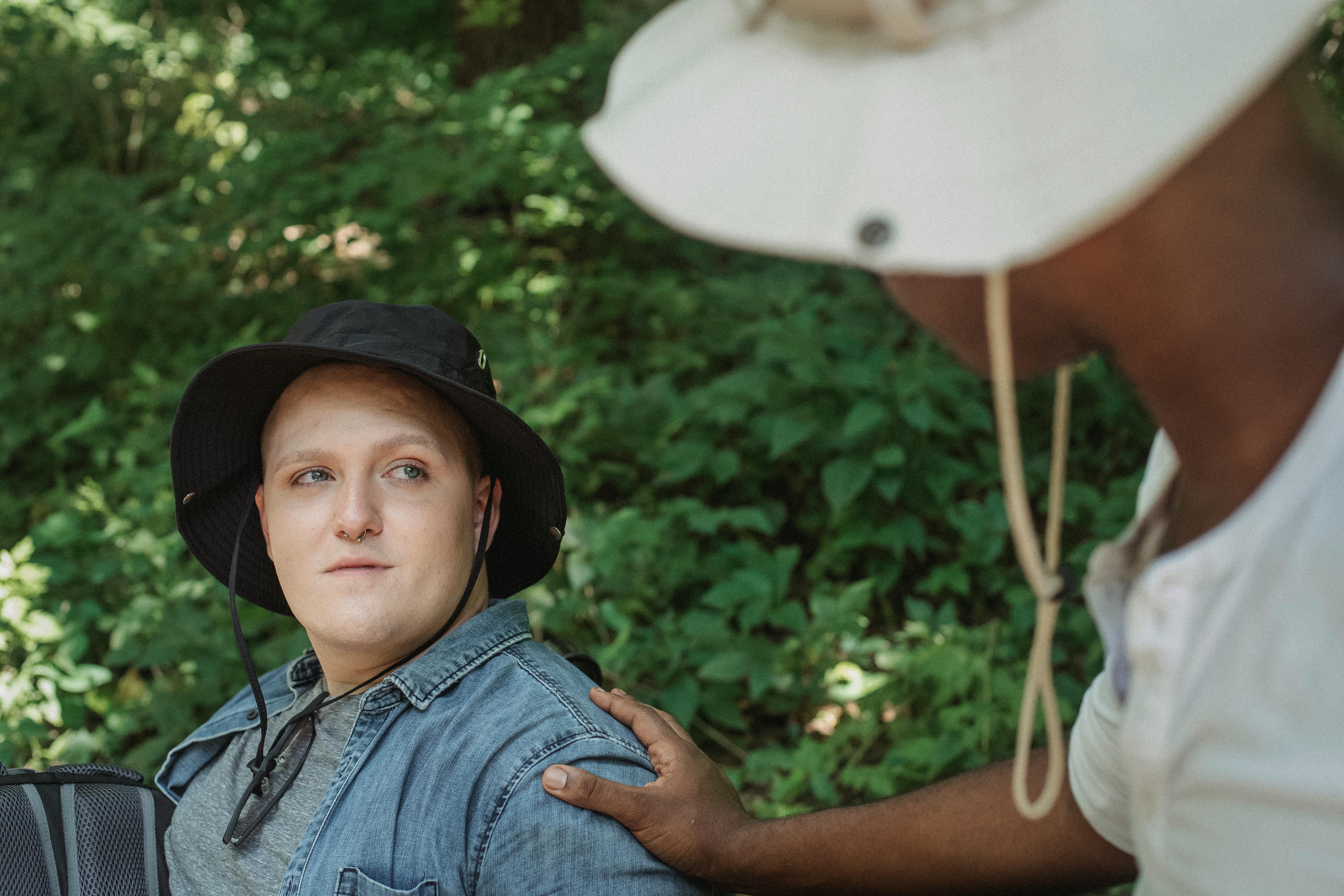 crop homosexual black man touching shoulder of partner in park