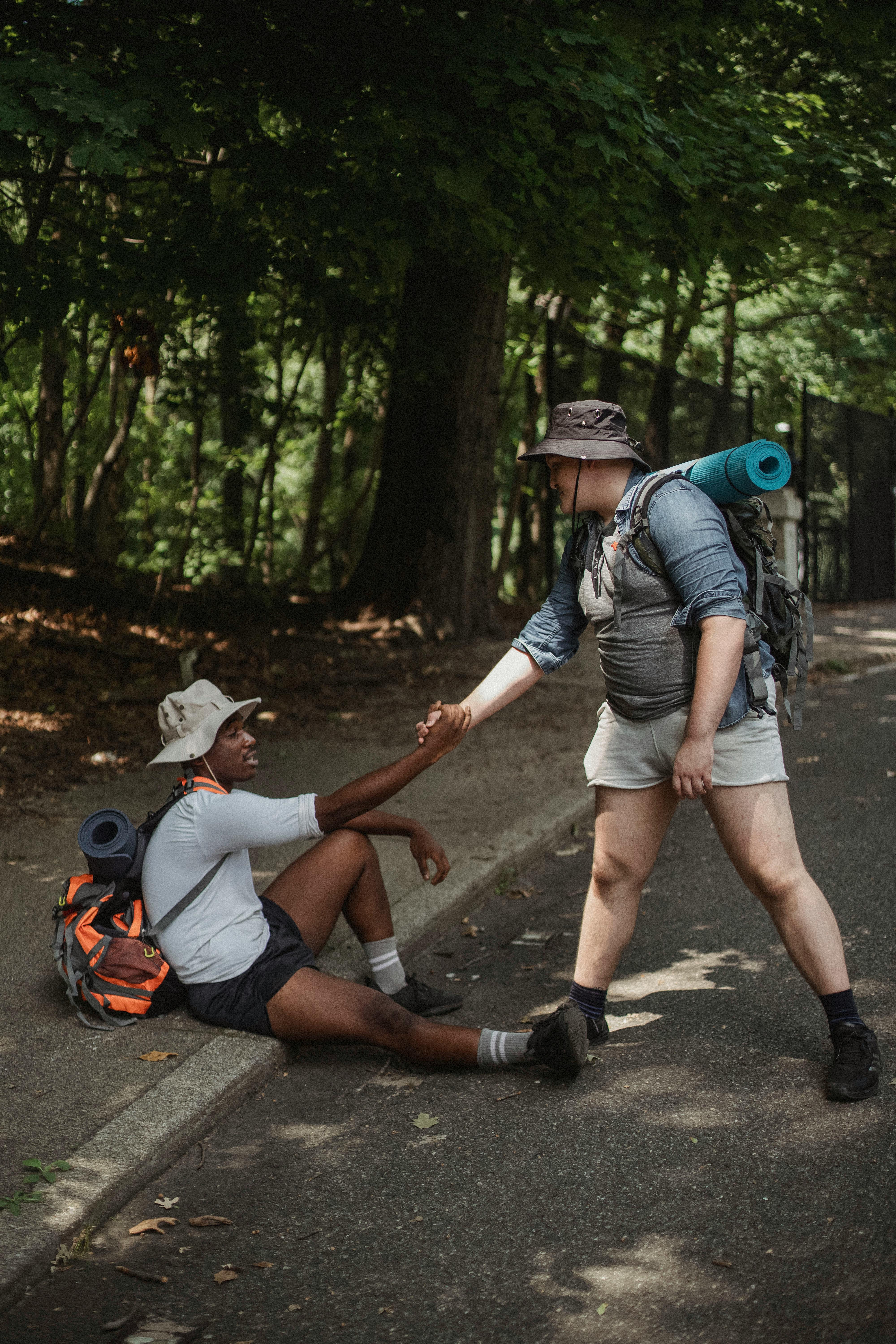 hiker holding hand of black friend on road