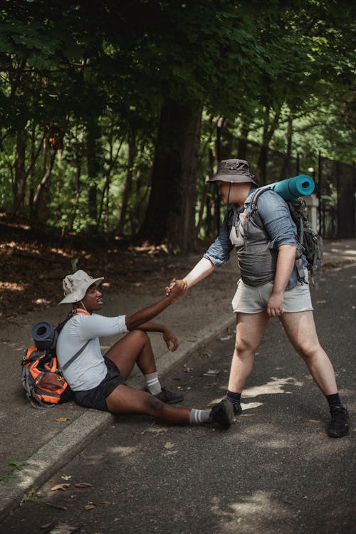 Hiker holding hand of black friend on road