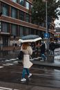 一名妇女打着雨伞，走在阿姆斯特丹潮湿的街道上