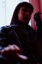 一个在低光环境下妆容和服装风格都很大胆的女人