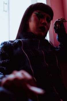 一个在低光环境下妆容和服装风格都很大胆的女人