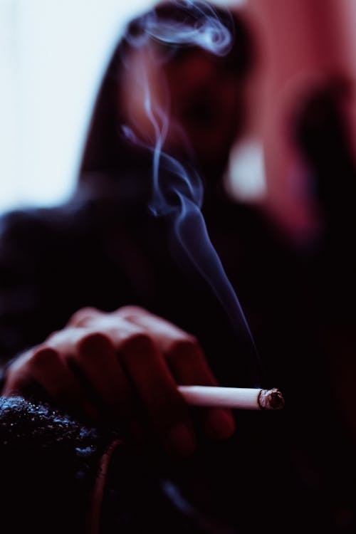 Gratis Wanita Yang Tidak Bisa Dikenali Sedang Merokok Di Kamar Foto Stok
