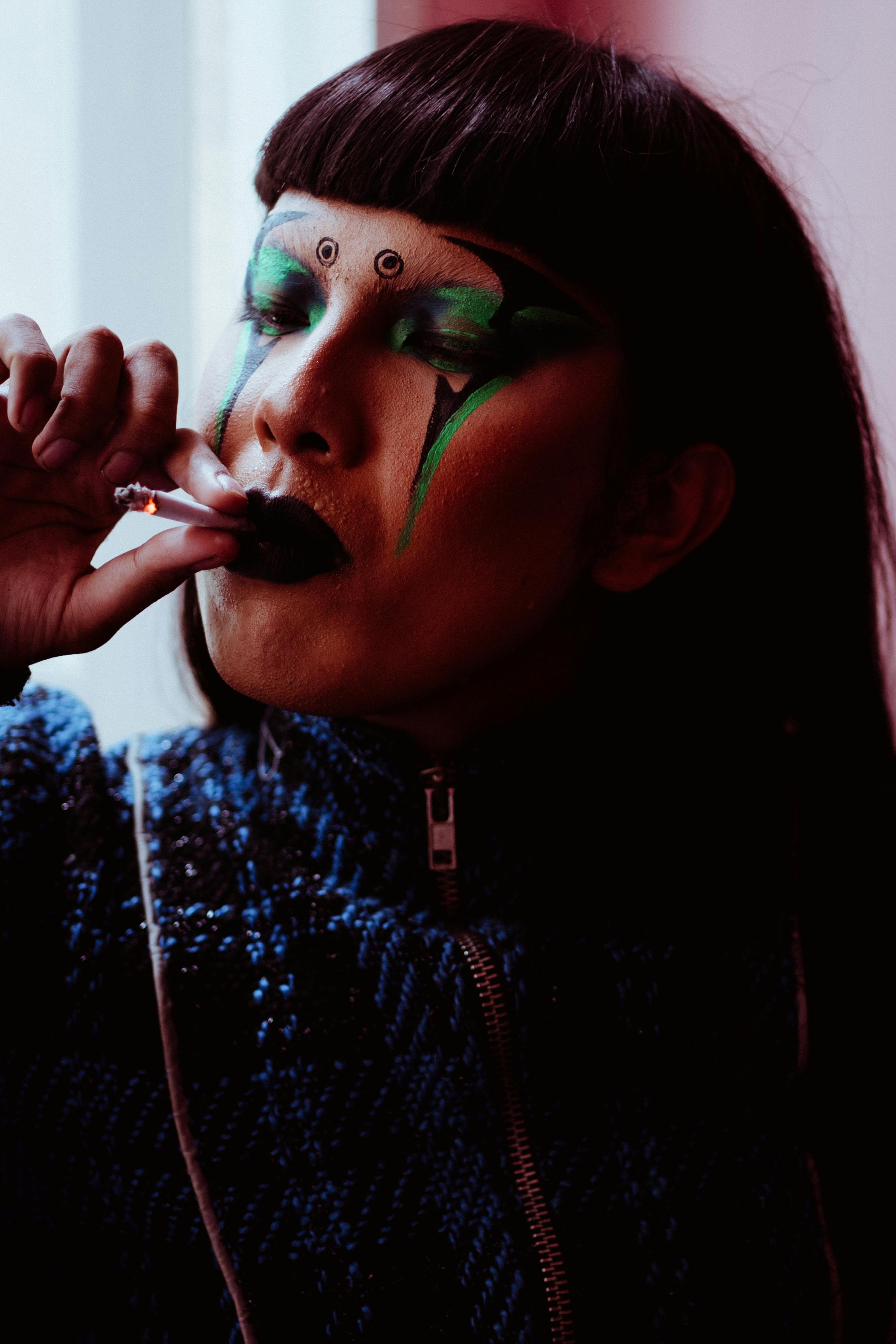 asian woman with makeup smoking cigarette