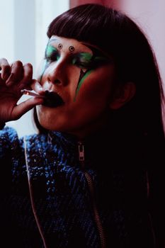 一个女人在室内吸烟，她的艺术肖像带有戏剧性的化妆