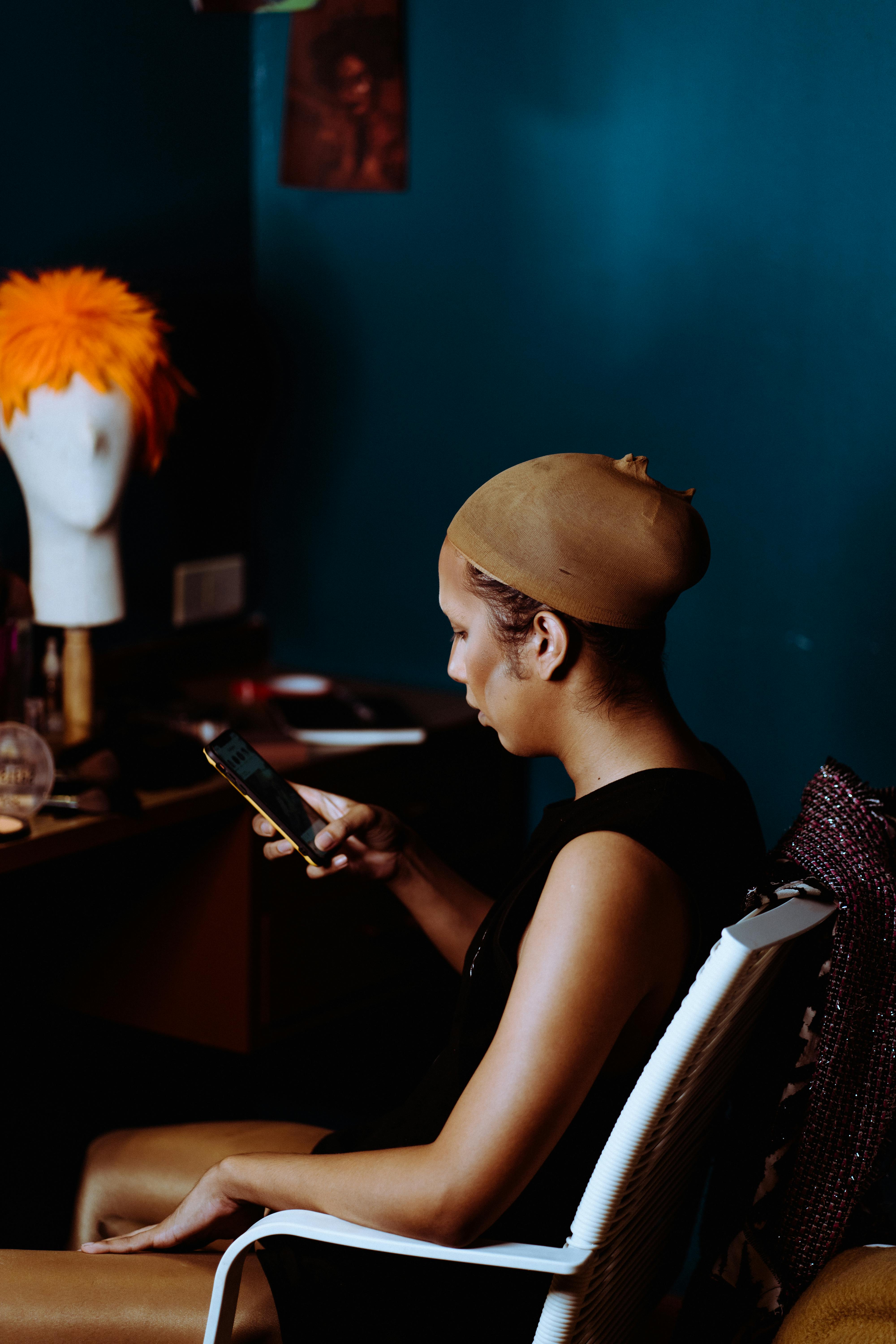 young woman with foundation on face using smartphone