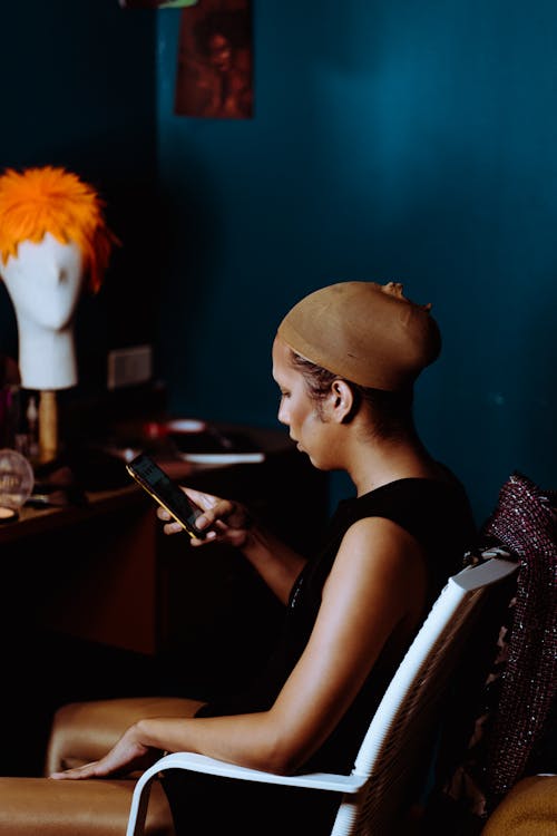 Young woman with foundation on face using smartphone