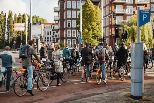 Free Group of urban cyclists waiting at a traffic light on a busy city street. Stock Photo