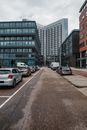 市中心的现代街景中，停放着汽车，矗立着高层建筑