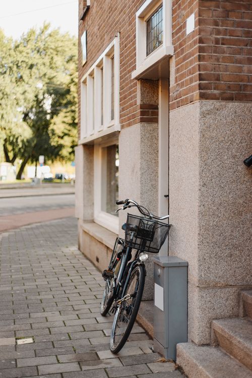 Free A bicycle parked outside a brick building on a cobblestone street, capturing urban life. Stock Photo
