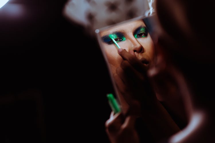 Crop Ethnic Woman Doing Makeup On Eyelid Reflecting In Mirror