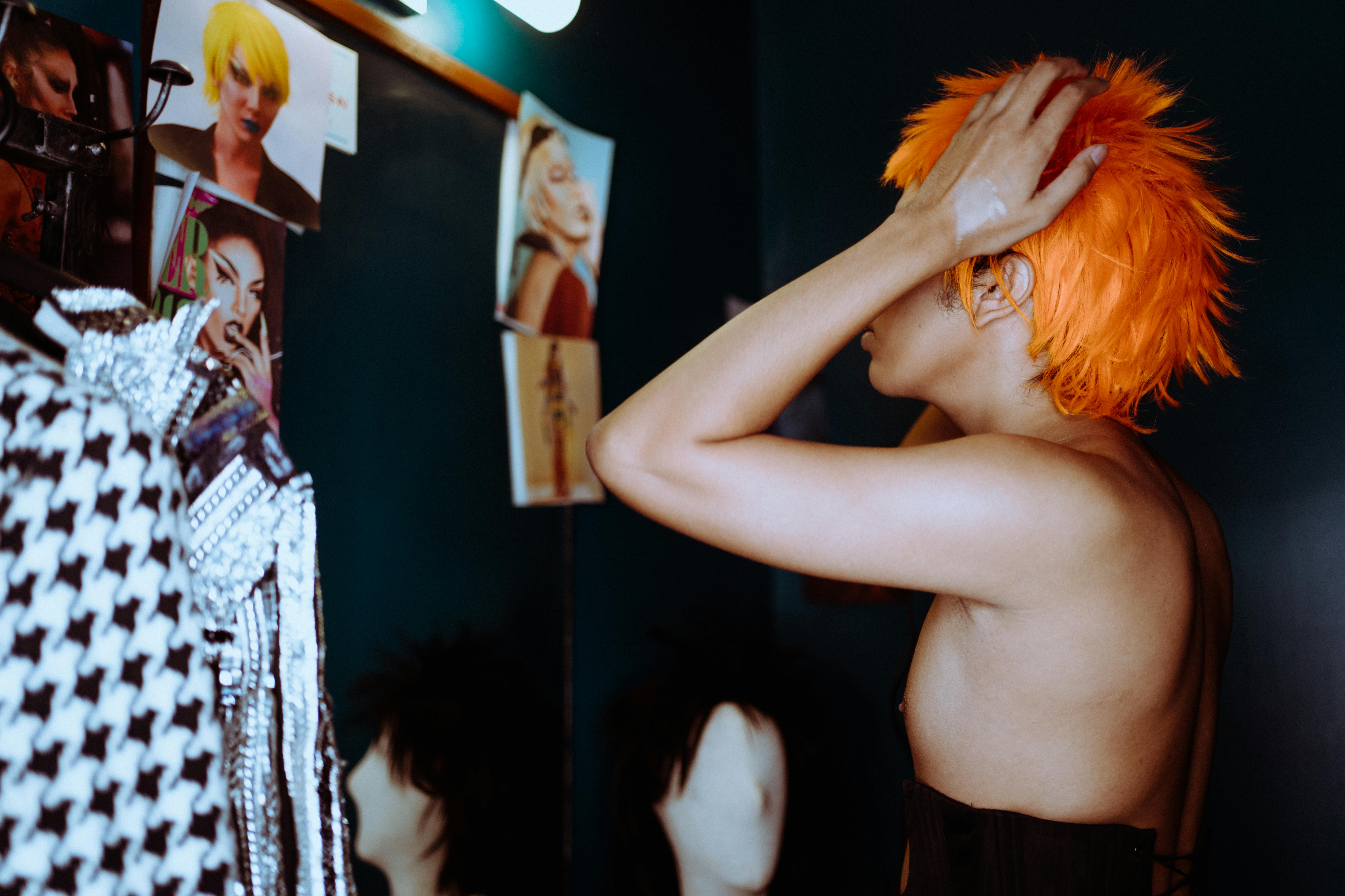 stylish ethnic androgynous man in bright wig