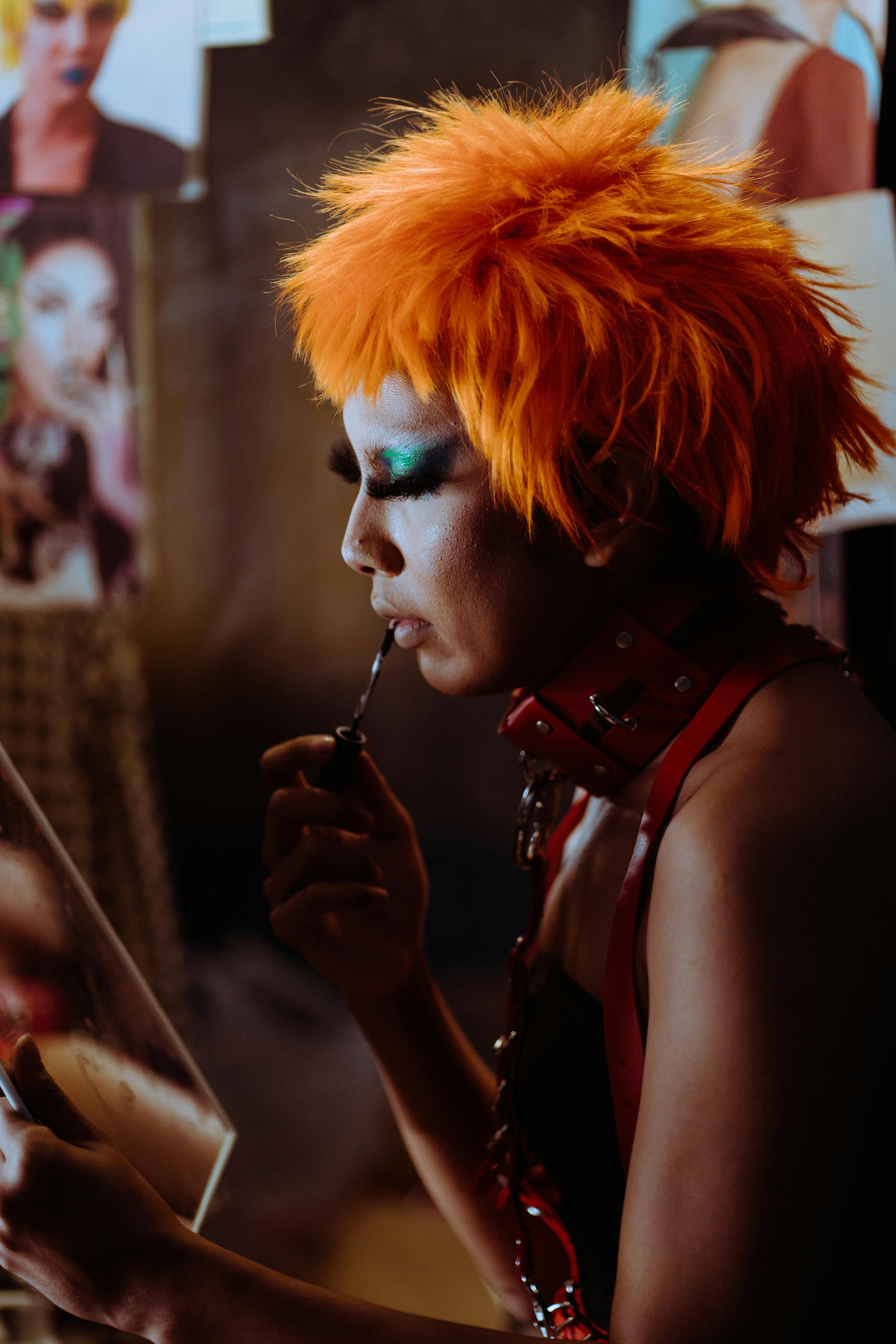 focused ethnic transsexual artist applying makeup before show