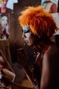 Focused ethnic transsexual artist applying makeup before show