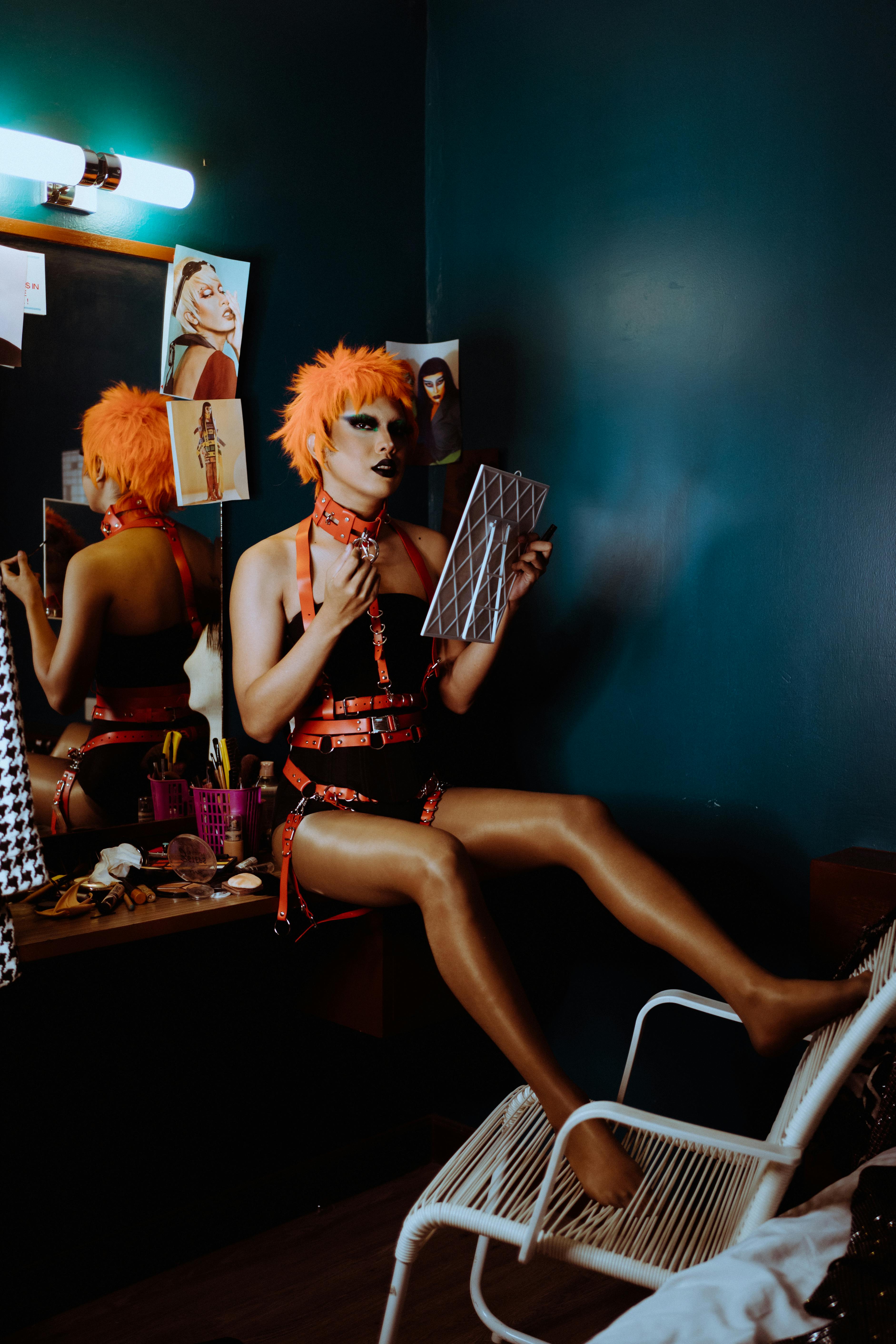 Sensual young transsexual guy in BDSM clothes sitting in dressing room near  mirror · Free Stock Photo