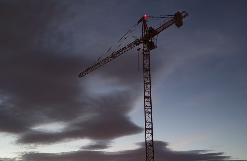 Tower crane lit up against the night sky on an industrial build