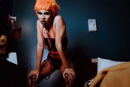 Crop transgender with bright make up standing in bedroom