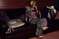 一位穿着奢华斑马纹服装、头发充满活力的时尚女性坐在沙发上