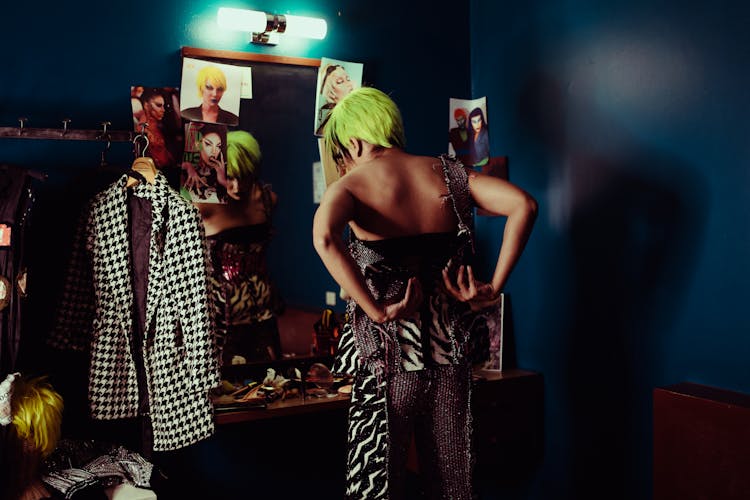 Trendy Actress Putting On Clothes Near Mirror In Makeup Room