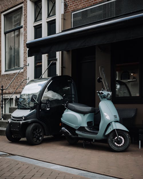 Motorino Bianco E Nero Parcheggiato Accanto Alla Casa Bianca E Nera