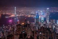 从高视角俯瞰香港的夜间天际线，以标志性的摩天大楼和绚丽的灯光为特色
