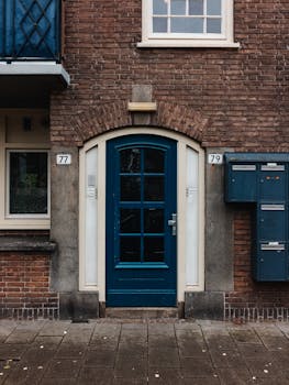 Charming entrance with blue wooden door and brick wall facade on urban street.