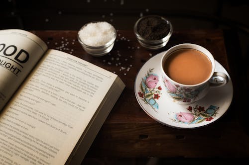 Free A Cup of Coffee Beside an Open Book Stock Photo