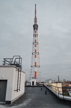 城市环境中，多云天空下，屋顶上高耸着电信结构
