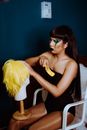 Man crossdresser in bodysuit preparing wig