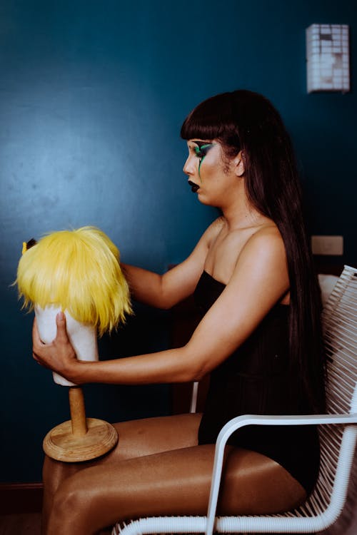 Gratis Crossdresser Muda Memegang Manekin Dengan Wig Foto Stok