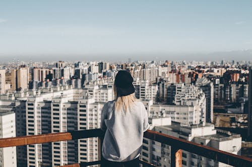 Woman in Gray Sweatshirt Standing on Top of Building