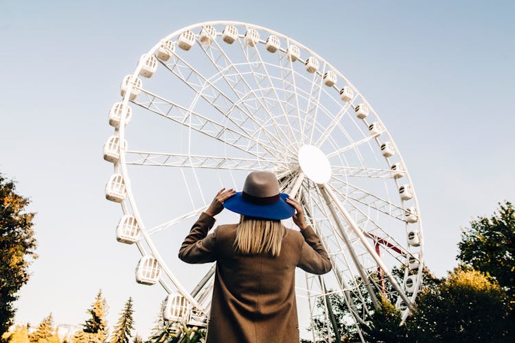 A Woman Standing Near A Ferris Wheel