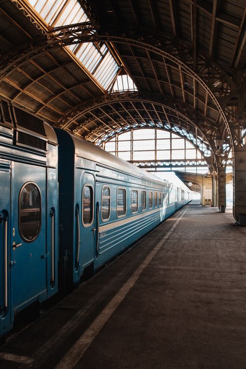 Free A classic blue train awaits departure at an elegant arched railway station. Stock Photo