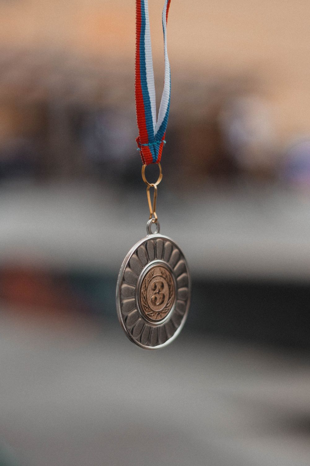 Close-up of a silver medal with tricolor ribbon