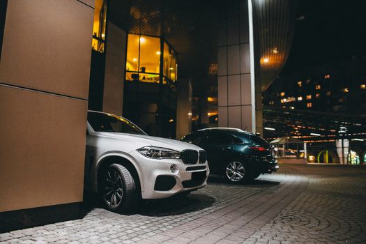 夜晚，现代汽车停靠在城市建筑下，彰显出豪华与城市生活的气息