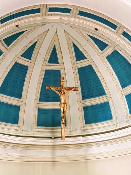 Free Elegant crucifix suspended under an ornate church dome, striking blue and white design in Petersfield, UK. Stock Photo