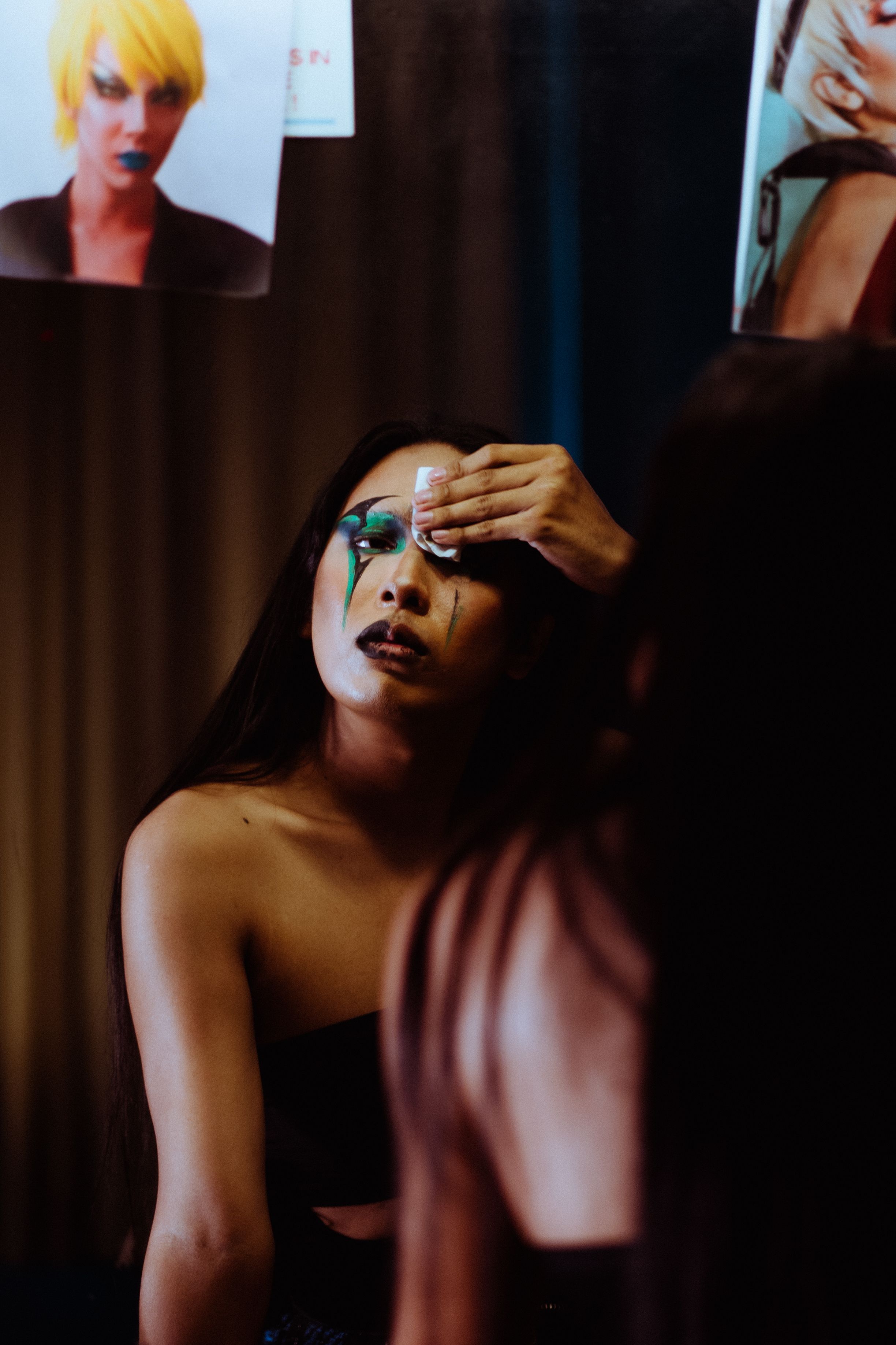 A person in front of a mirror working on their makeup