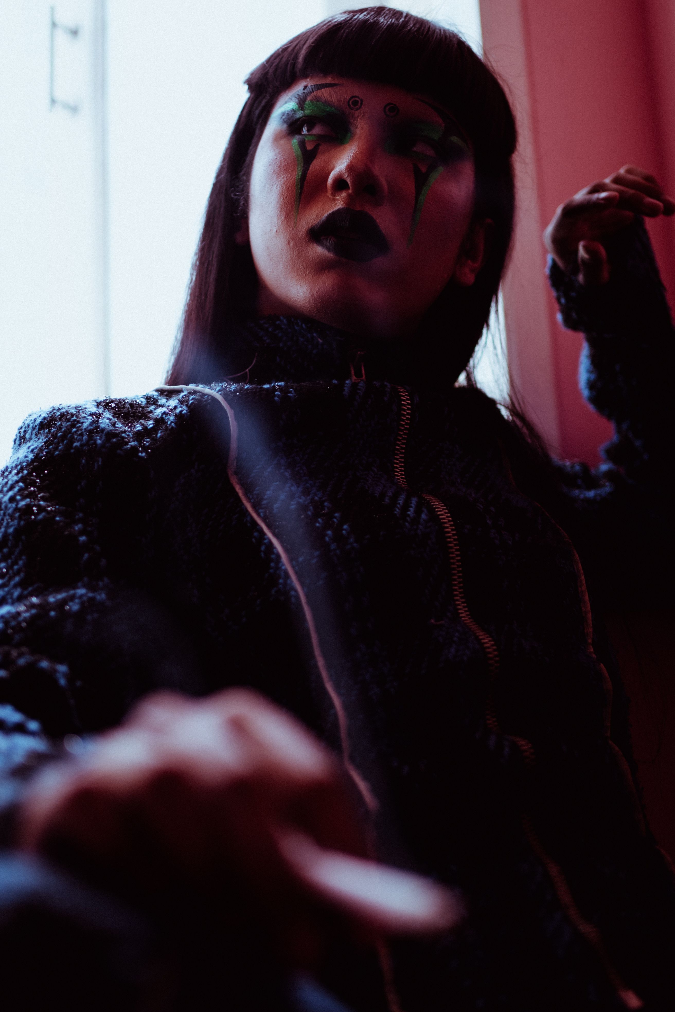 A feminine-presenting person in an editorial portrait near a window