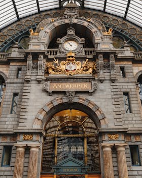 Close-up of the ornate facade at Antwerp Central Station showcasing historic architecture. by Max Avans