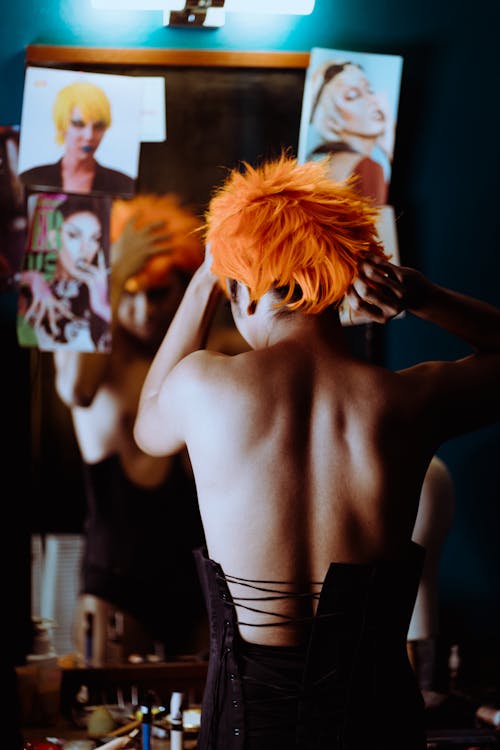 Informal woman putting on orange wig