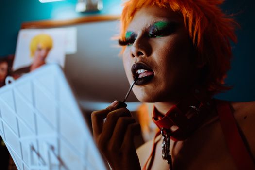 Crop funky woman applying black lipstick