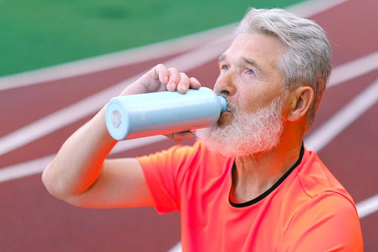 Senior Man Drinking Water From Thermos